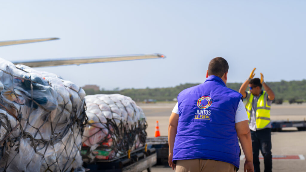 Pallets de ayuda humanitaria en la pista junto al avión, recibidos por el equipo de Juntos Se Puede en Venezuela